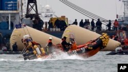 FILE - Searchers and divers look for people believed to have been trapped in the sunken ferry boat Sewol near the buoys which were installed to mark the vessel in the water off the southern coast near Jindo, south of Seoul, South Korea, April 22, 2014.