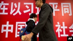 北京街頭的行人走過宣傳習近平的標語。