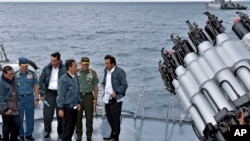 In this June 23, 2016 file photo released by the Indonesian Presidential Office, Indonesian President Joko Widodo, third right, accompanied by Indonesian officials on navy warship KRI Imam Bonjol, at the Natuna Islands, Indonesia.