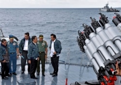 Presiden Joko Widodo, ketiga kanan, didampingi pejabat kapal perang TNI AL KRI Imam Bonjol, di Kepulauan Natuna. (Foto: via AP)