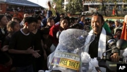 Lhakpa Tsering, on the motorbike, is greeted by school children as he arrives at the Tibetan Children's Village School in Dharmsala, India, Thursday, Oct. 28, 2010. Tsering, a Tibetan refugee living in New York, arrived here after traveling on his motorbi