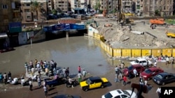 In this Oct. 25, 2015 file photo, Egyptians check floodwaters after a heavy rainfall in the coastal city of Alexandria, Egypt. (AP Photo/Heba Khamis, File)