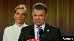 Presiden Kolombia Juan Manuel Santos, didampingi istrinya Maria Clemencia de Santos, berbicara kepada media di Bogota setelah mendapatkan Hadiah Nobel Perdamaian (7/10). (Reuters/John Vizcaino)