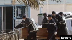 Rescue workers carry the coffin of one of the hostages killed during a hostage crisis in a gas plant at the hospital in In Amenas, January 21, 2013.