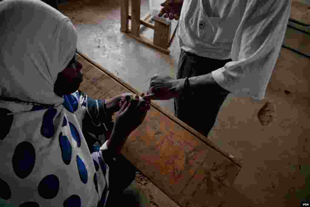 An IEBC official inks a voter&#39;s finger after he cast his ballot, March 4, 2013. (R. Gogineni/ VOA)