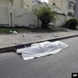 The body of a person killed during clashes between demonstrators and police lies in the street in Manama, February 17, 2011