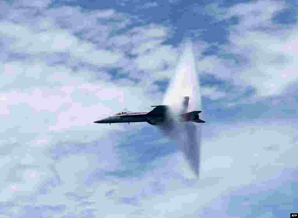 This U.S. Navy handout photo shows an F/A-18E Super Hornet assigned to the &quot;Tomcatters&quot; of Strike Fighter Squadron (VFA) 31 as it breaks the sound barrier above the aircraft carrier USS George H.W. Bush (CVN 77) during an air power demonstration over the Atlantic Ocean.