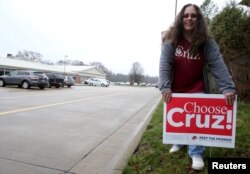 Pam Catlin places a sign for Republican presidential candidate Ted Cruz just outside a polling location on Super Tuesday in Valley City, Ohio, March 15, 2016.