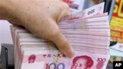 香港某外汇兑换店的职员点算一把百元人民币。（资料照）