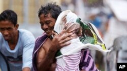 Residents of the slum community of Baseco evacuate to safer grounds at the onslaught of typhoon Rammasun, July 16, 2014 in Manila, Philippines. 