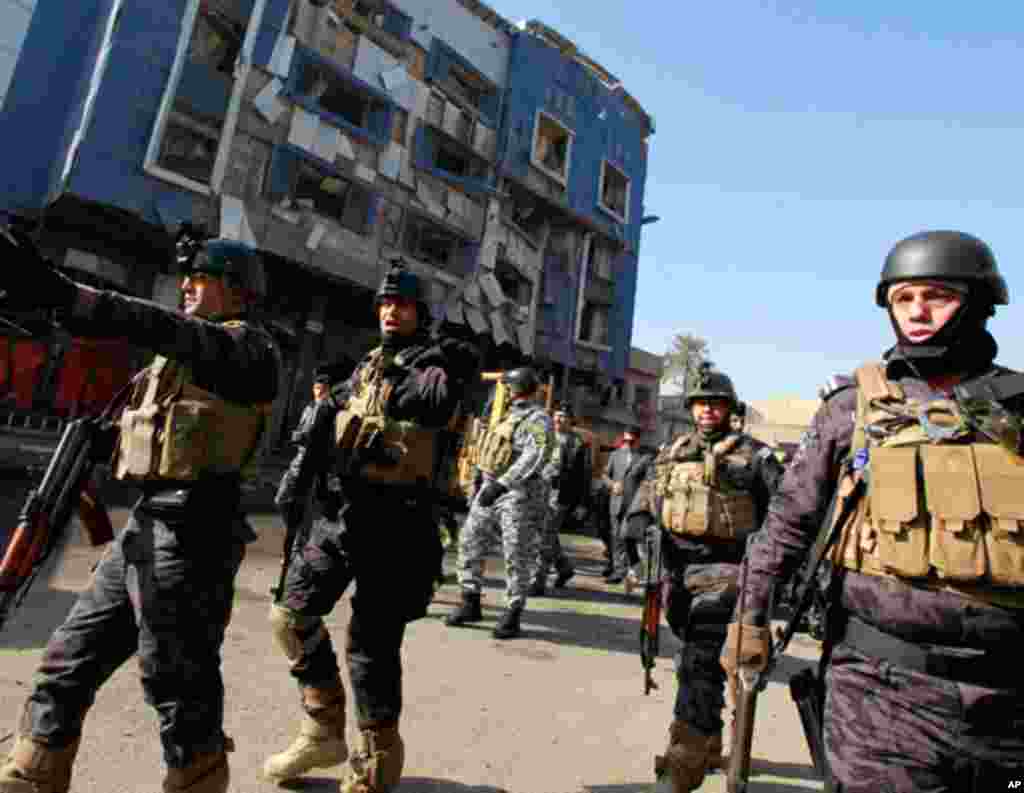 Iraqi security forces inspect the scene of a bomb attack in Kazimiyah in the north of Baghdad on January 5, 2012. (AP)