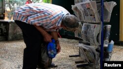 FILE - A man looks at newspapers on display in Algiers,. Taken Sept. 21, 2010.
