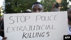 یکی از معترضان تکزاسی به عملکرد پلیس آمریکا علیه سیاهپوستان. روی پلارکارد نوشته شده: قتلهای خودسرانه توسط پلیس را متوقف کنید 