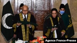 This handout photograph taken on Jan. 24, 2022, released by the Pakistan’s Press Information Department, shows chief justice Gulzar Ahmed
administering the oath to justice Ayesha Malik, in Islamabad. (Photo by Pakistan Press Information Department/AFP)
