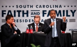 Ben Carson, accompanied by South Carolina Attorney General Alan Wilson, left, and Dr. Oran Smith of the Palmetto Family Council, speaks during the Faith and Family Presidential Forum at Bob Jones University in Greenville, S.C., Feb. 12, 2016.
