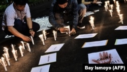 Sejumlah pengunjuk rasa menyalakan lilin dalam demo di depan istana kepresidenan untuk memprotes hukuman mati di Jakarta. (Foto/dok: Bay Ismoyo/AFP) 