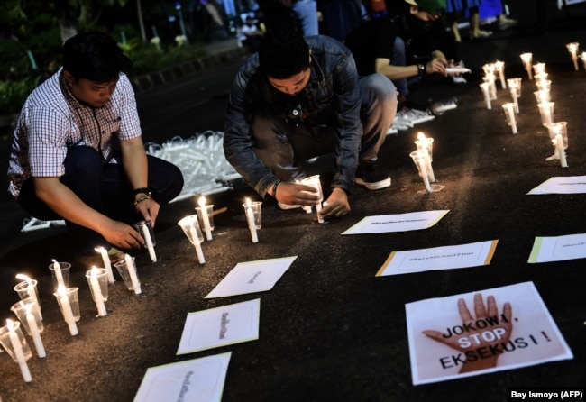 Sejumlah pengunjuk rasa menyalakan lilin dalam demo di depan istana kepresidenan untuk memprotes hukuman mati, Jakarta, 28 Juli 2016. (Foto: Bay Ismoyo/AFP)
