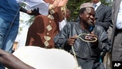 A man smiles as he receives his sheep for Tabaski