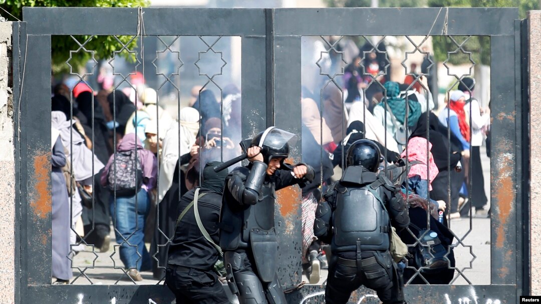 Polisi Mesir berusaha mendobrak pintu masuk di Universitas Al-Azhar dalam bentrokan dengan pendukung Ikhwanul Muslimin (19/3).