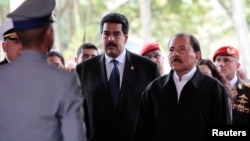 Nicaragua's President Daniel Ortega (R) stands next to Venezuela's Vice-President Nicolas Maduro (C) as they visit the wake of late Venezuelan President Hugo Chavez, which is lying in state, at the military academy in Caracas March 9, 2013, in this pictur