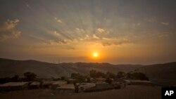 The sun rises over West Bank hamlet of Khan al-Ahmar, Sept. 13, 2018. The Palestinian residents of Khan al-Ahmar cling to hopes that international pressure can save their strategically located West Bank hamlet from Israeli army bulldozers.