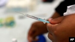 A Johnson and Johnson booster vaccine is prepred at the Vaccination Centre of Hope at the Cape Town International Convention Centre in Cape Town, South Africa on Nov. 30, 2021, as part of the Sisonke trial for healthcare workers. 