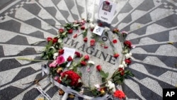 Flowers adorn the Imagine mosaic in remembrance of John Lennon, in the Strawberry Fields section of New York's Central Park, Tuesday, Dec. 8, 2015. Thirty-five years ago, Mark David Chapman shot and killed the former the Beatle. (AP Photo/Richard Drew)