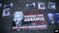 Banners in support of WikiLeaks founder Julian Assange are displayed outside Westminster magistrates court where he was appearing in London, Thursday, April 11, 2019.