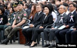 6일 오전 서울 동작구 국립서울현충원에서 열린 제62회 현충일 추념식에서 문재인 대통령 곁에 국가유공자와 목함지뢰 부상자들이 앉아있다. 왼쪽부터 북한 지뢰도발로 부상당한 김정원· 하재헌 중사, 문 대통령, 대통령 부인 김정숙 여사, 국가유공자 박용규씨, 박씨 아들 박종철씨.