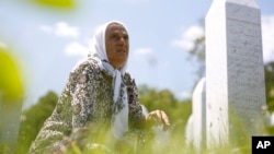 Bosnian Muslim woman Izeta Alihodzic offers prayers near grave of her son at the memorial center of Potocari, near Srebrenica, July 10, 2015.