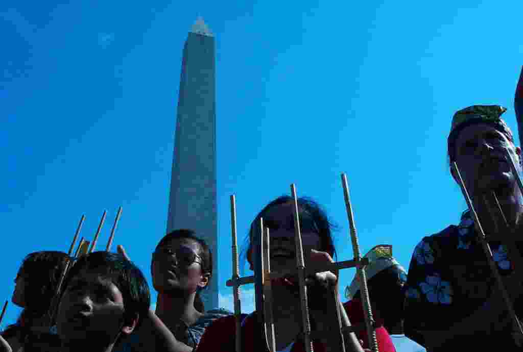 Warga Indonesia de Amerika dan warga setempat berdiri berdampingan memainkan anglung dalam acara ini (foto: Ratnasari Dewi-VOA)