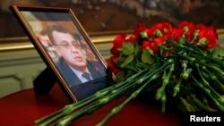 Flowers are placed near a portrait of assassinated Russian ambassador to Turkey Andrei Karlov during a meeting of Russian Foreign Minister Sergei Lavrov with his Turkish counterpart Mevlut Cavusoglu in Moscow, Russia, Dec. 20, 2016.