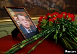 Flowers are placed near a portrait of assassinated Russian ambassador to Turkey Andrei Karlov during a meeting of Russian Foreign Minister Sergei Lavrov with his Turkish counterpart Mevlut Cavusoglu in Moscow, Russia, Dec. 20, 2016.