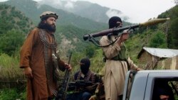 FILE - Pakistani Taliban patrol in then their stronghold of Shawal in Pakistani tribal region of South Waziristan, Aug. 5, 2012.
