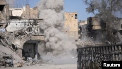 FILE - Smoke rises after a landmine is exploded as fighters of Syrian Democratic Forces clear roads after the liberation of Raqqa, Syria, Oct. 18, 2017. 