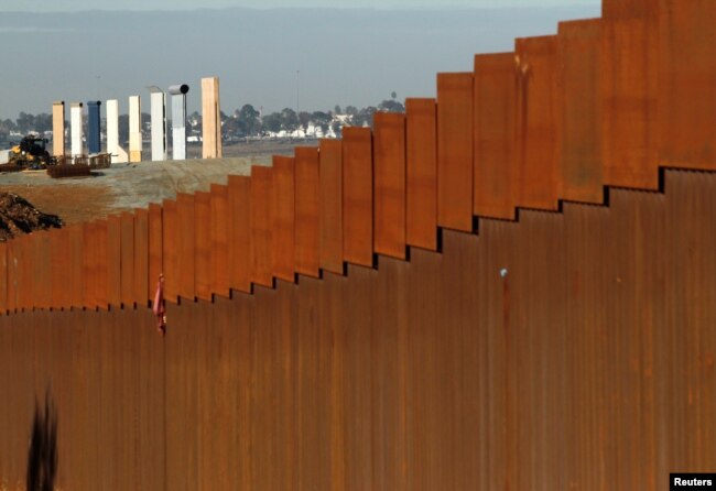 FILE - Prototypes for President Donald Trump's border wall are seen behind a border fence between Mexico and the United States, in Tijuana, Mexico, Jan. 7, 2019.