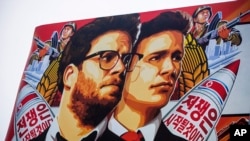 Spanduk film "The Interview" yang peluncurannya ditunda oleh Sony Pictures, dipasang di luar bioskop Arclight di Hollywood, California (17/12). (AP/Damian Dovarganes)