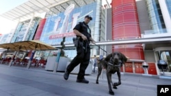 Officer Keith McCart, of the Long Beach, California, Police Department, patrols with K-9 Pidura outside the George R. Brown Convention Center, location of the Super Bowl 51 media center, Jan. 31, 2017, in Houston.