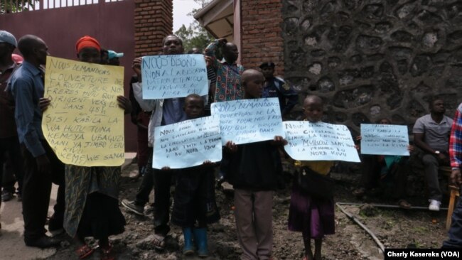 Des familles de l'ethnie Hutu brandissent des affiches exigeant l’autorisant d’exode vers l’Ituri devant le bureau du Gouverneur du Nord-Kivu, à Goma, 19 mai 2017. (Charly Kasereka)