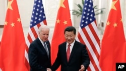 El presidente chino Xi Jinping, estrecha la mano del vicepresidente Joe Biden, en el Gran Hall del Pueblo, en Beijing. 