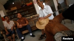 Một bệnh nhân bị ung thư dạ dày (trái) đang nói chuyện với bạn bè trong làng Shangba thuộc tỉnh Quảng Đông