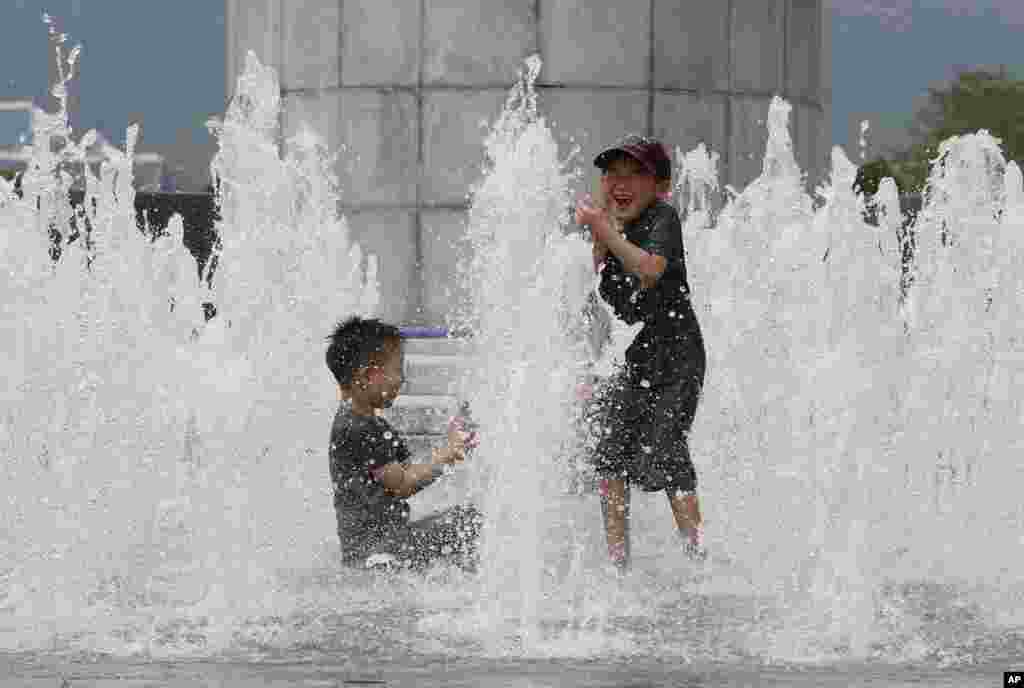 بچه ها در هوای گرم سئول از فواره برای خنک شدن استفاده می کنند. 