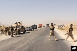 FILE - Afghanistan's security forces take their position during a clash by Taliban fighters in the highway between Balkh province to Kunduz city, north of Kabul, Afghanistan, Sept. 1, 2015.
