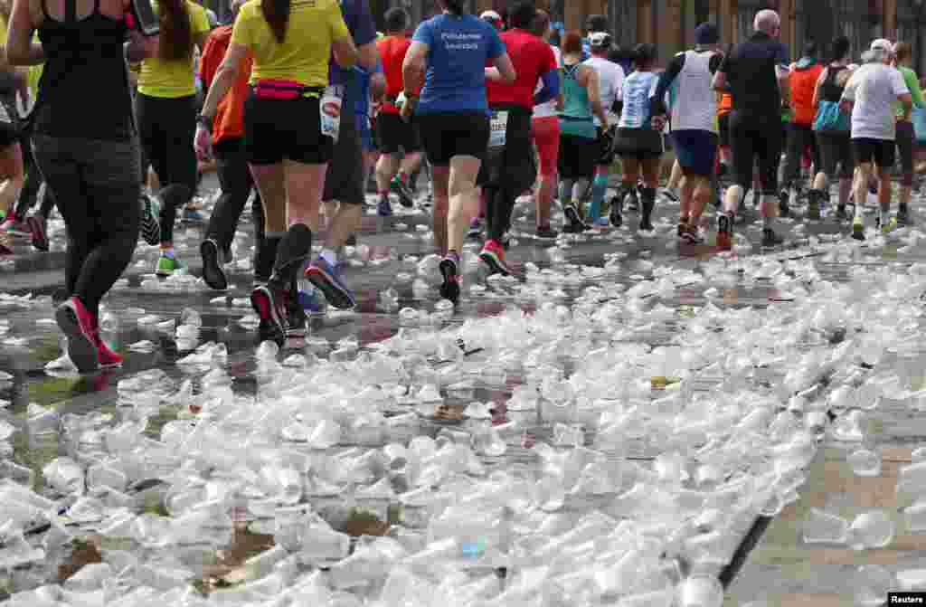 Runners pass along discarded cups at a refreshment point during the Vienna City Marathon in Vienna, Austria.