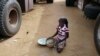 在马里北部的加奥，一个女孩子在捡拾一个人道救援车队不小心洒到地上的米