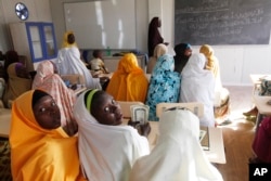 FILE - Children displaced by Boko Haram receive lessons in a school in Maiduguri, Nigeria, Dec. 7, 2015.