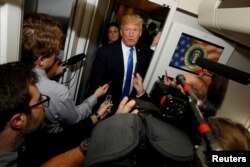 U.S. President Donald Trump speaks to reporters in the press cabin aboard Air Force One as they depart home to the U.S. from Ninoy Aquino International Airport in Manila, Philippines, Nov. 14, 2017.