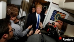 FILE - U.S. President Donald Trump speaks to reporters in the press cabin aboard Air Force One, Nov. 14, 2017. 