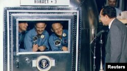 時任美國總統的尼克松1969年7月在太平洋上的美國海軍"大黃蜂號"航空母艦上歡迎返回地球的"阿波羅11號"登月使命的三名太空人：(從左至右)指揮長阿姆斯特朗、指揮艙駕駛員柯林斯和登月艙駕駛員奧爾德林。