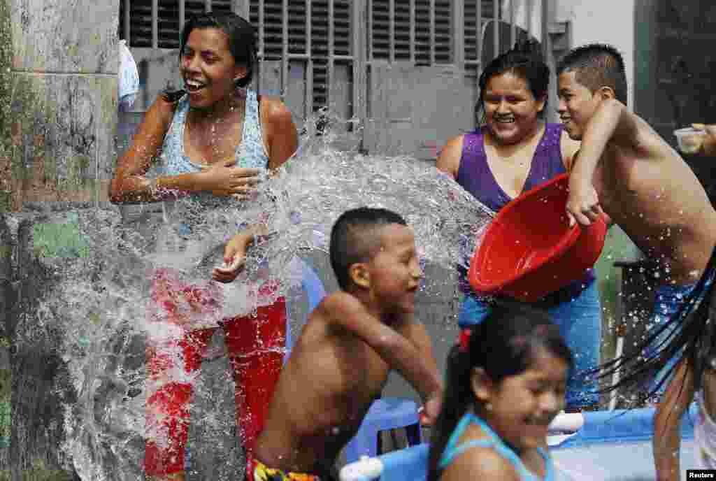 여름인 페루 리마에서 더위를 식히기 위해 물장난을 하고 있다.